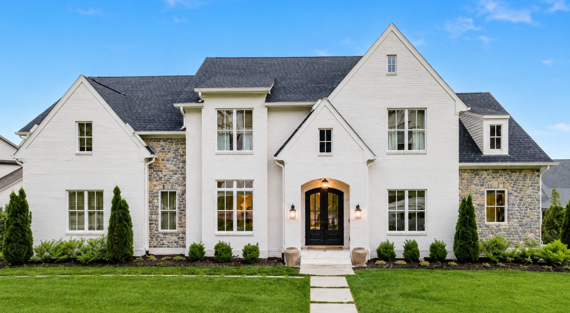 Luxury white brick home with stone accents and manicured lawn | Riley King real estate portfolio